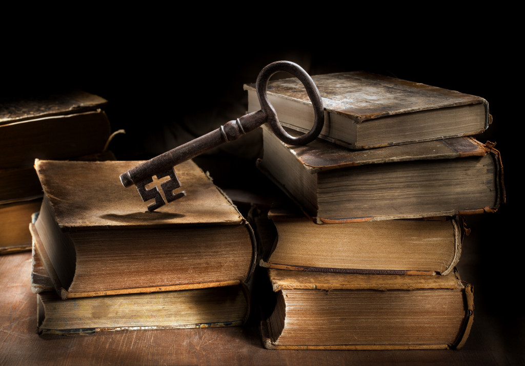 Conceptual still life image of old antique books and a big old key.